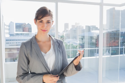 Businesswoman holding clipboard and smiling