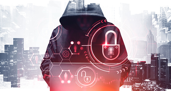 Hacker with laptop in city, security Unrecognizable young hacker in hoodie using laptop in blurry city. Concept of cybersecurity. Toned image. Double exposure of security interface