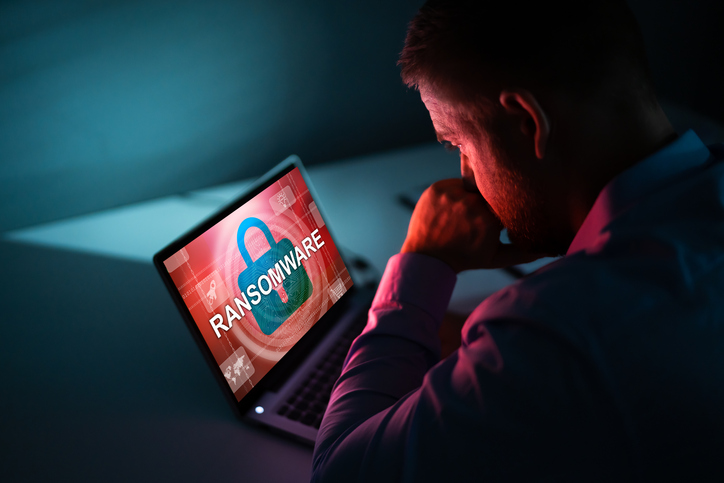 Person Looking At Laptop Screen Worried Businessman Looking At Laptop With Ransomware Word On The Screen At The Workplace